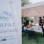 Equipo de CAPAZ atendiendo su módulo informativo.