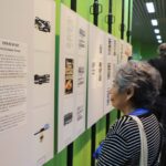 Visitante observa una exposición de textos y obras artísticas.