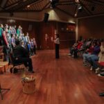 Coro infantil y juvenil se presenta ante el público.